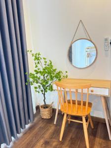 una scrivania con uno specchio e una sedia di legno di Vile Villa- Homestay 2 Đảo Phú Quý a Cu Lao Thu