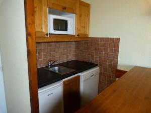 a small kitchen with a sink and a microwave at Résidence Ruitor Arc 1800 - Appartement 2 pièces 5 personnes dans une résidence calme, proche du télécabine dans le village de Charmettoger à Arc 1800 MAE-2190 in Arc 1800