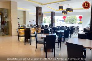 a dining room with tables and chairs in a restaurant at G-Hotel Pontianak in Pontianak