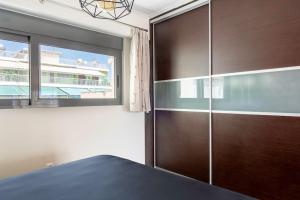 1 dormitorio con armario grande de madera y ventana en Comfort 1BR apt with amazing balcony at Piraeus, en Pireo