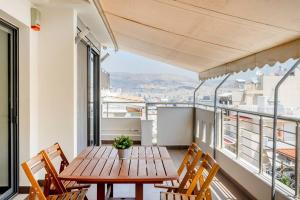 balcón con mesa y sillas de madera en Comfort 1BR apt with amazing balcony at Piraeus, en Pireo