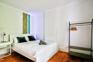 a white bedroom with a white bed with blue pillows at Elegant 2 BR on the edge of Downtown Dowling St 2 E-Bikes Included in Sydney