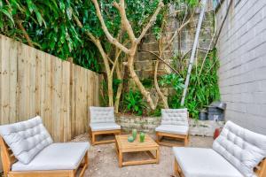 a patio with couches and chairs and a tree at Elegant 2 BR on the edge of Downtown Dowling St 2 E-Bikes Included in Sydney