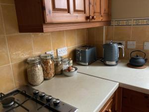 a kitchen counter with jars of food and a stove at Cosy at Cumberland - Double room with shared bathroom in Dundonald