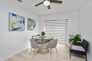 a dining room with a glass table and chairs at Blue Door Duplex Renovated Parking and Designed in Cutler Bay +20 photos