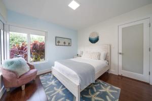 a bedroom with a bed and a chair and a window at Boho House - Stylist Home with Parking and large Yard in Miami