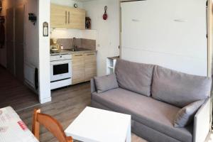 un soggiorno con divano e una cucina di Résidence Pic Vert - Studio pour 4 Personnes 204 a Les Orres