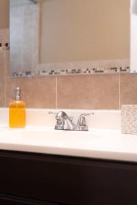 a bathroom sink with a soap dispenser on it at Travelers Hideout Located 1 block from the beach in Miami Beach