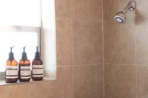 a shower with two bottles sitting on a shelf at Travelers Hideout Located 1 block from the beach in Miami Beach