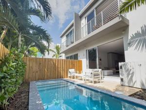 a house with a swimming pool next to a fence at The Modernista 1 - Luxury Villa with Private Pool in Miami