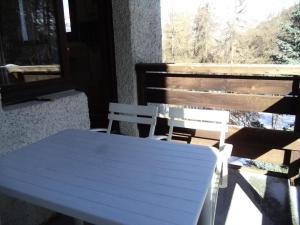 a white table and chairs on a porch with a window at Résidence Le Meale - Studio pour 4 Personnes 891 in Les Orres