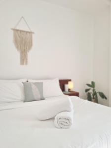 a white bed with a pile of towels on it at 148 Guesthouse and Resort in Alaminos
