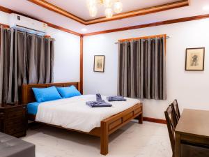 una camera da letto con un letto con cuscini blu e un tavolo di Onjira Resort 