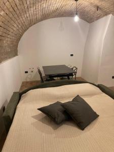 Cette chambre comprend un lit avec deux oreillers et une table. dans l'établissement Il Volto, à Valeggio sul Mincio