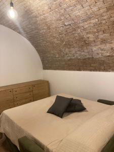 - une chambre avec un lit et un mur en briques dans l'établissement Il Volto, à Valeggio sul Mincio