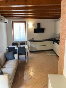een woonkamer met een bank en een keuken bij Il Volto in Valeggio sul Mincio