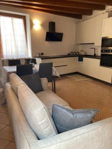 een woonkamer met een bank en een keuken bij Il Volto in Valeggio sul Mincio