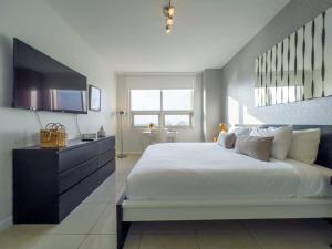 a large bedroom with a large bed and a television at Palm Place Heart of Miami with Parking Pool and Gym in Miami