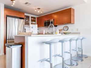 a kitchen with a counter with bar stools at Palm Place Heart of Miami with Parking Pool and Gym in Miami
