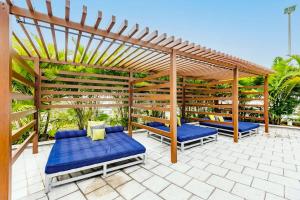 a pergola with two beds and blue cushions on a patio at Palm Place Heart of Miami with Parking Pool and Gym in Miami