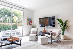 uma sala de estar com mobiliário branco e uma grande janela em The Modernista 2 - Large Townhome with Pool and Parking em Miami