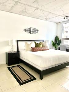 een slaapkamer met een groot wit bed in een kamer bij City Condo in Midtown Wynwood with pool and parking in Miami