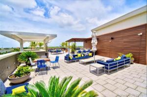 een patio met blauwe en gele stoelen en tafels bij City Condo in Midtown Wynwood with pool and parking in Miami