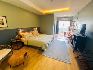 a bedroom with a bed and a flat screen tv at Forget Me Not Boutique Bed & Breakfast Hua Hin in Hua Hin