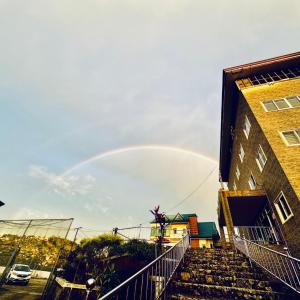 un arco iris en el cielo sobre un edificio en Baguio BELL Staycation, en Baguio