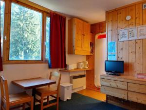 a kitchen with a table and a desk with a television at Résidence Nova - Studio pour 2 personnes, au coeur de la station d'Arc 1800 dans le village des Villards MAE-2221 in Arc 1800