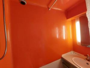 an orange bathroom with a toilet and a sink at Résidence Nova - Studio pour 2 personnes, au coeur de la station d'Arc 1800 dans le village des Villards MAE-2221 in Arc 1800
