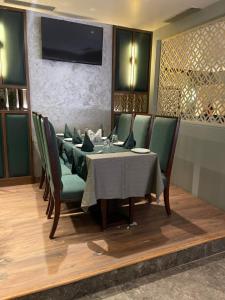 a dining room with a table and green chairs at Green Hotel & Restaurant in Pathānkot
