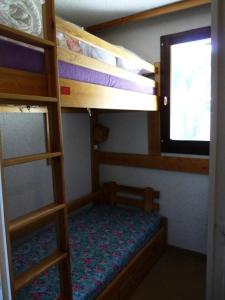 sypialnia z 2 łóżkami piętrowymi i oknem w obiekcie Résidence Orrianes Des Cimes - Studio pour 4 Personnes 851 w mieście Les Orres