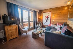 a living room with a couch and a television at VALERIANE G - Appartement VALERIANE 118 pour 4 Personnes 07 in Valmorel