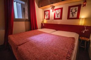 a bedroom with a red bed with a red blanket at VALERIANE G - Appartement VALERIANE 118 pour 4 Personnes 07 in Valmorel