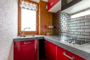 a kitchen with red cabinets and a sink at CRISTALLIN G - Appartement CRISTALLIN 47 pour 4 Personnes 10 in Valmorel