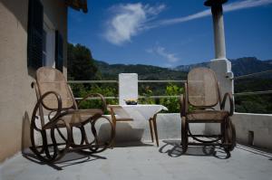 3 sillas y una mesa en un balcón con vistas en Sa Roca Roja, en Sóller