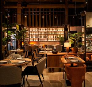 毕尔巴鄂Bilder Boutique Hotel的有桌椅和酒瓶的餐厅