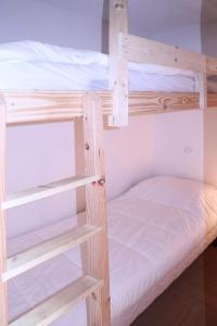 ein paar Etagenbetten mit weißer Bettwäsche in der Unterkunft Résidence Parc Des Airelles - 2 Pièces pour 8 Personnes 251 in Les Orres