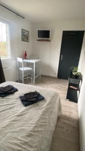 Saligny-sur-RoudonにあるChambre double chez Audreyのベッドルーム1室(ベッド1台、テーブル、テーブル付)