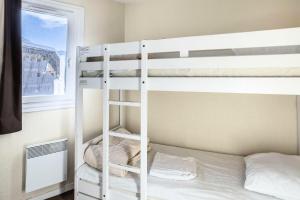- deux lits superposés dans une chambre avec fenêtre dans l'établissement Résidence Quartier Falaise - maeva Home - Appartement 2 Pièces 6 Personnes 524, à Avoriaz