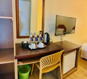 a desk with a mirror and a chair in a room at Sogo Hotel 2 in Labuan