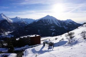 une montagne couverte de neige avec un bâtiment au sommet dans l'établissement Résidence Plein Soleil Ii - studio cabine 4 personnes MAE-2800, à Orcières