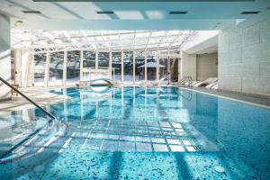 una piscina con acqua blu in un edificio di Golf Hotel a Folgaria