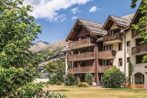 aominium building with balconies and mountains in the background at Résidence L'Alpaga - maeva Home - Appartement 2 Pièces 7 Personnes - Budge 524 in La Salle-les-Alpes