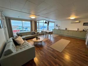 uma sala de estar com um sofá e uma mesa em Det grønne hus med isbjergsudsigt em Ilulissat