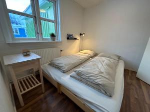 małe łóżko w pokoju z oknem w obiekcie Det grønne hus med isbjergsudsigt w mieście Ilulissat