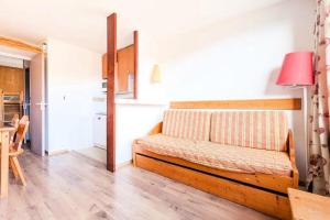 ein Wohnzimmer mit einer Bank in einem Zimmer in der Unterkunft Résidence Les Mélèzes - maeva Home - 2 Pièces 6 Personnes - Confort 144 in Huez