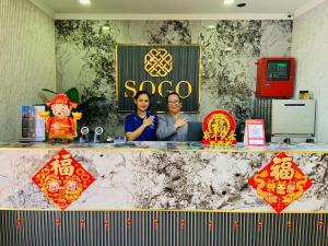two women sitting behind a counter with signs on it at Sogo Hotel 2 in Labuan