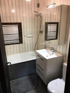 a bathroom with a sink and a tub and a toilet at Résidence Chal. Les Chandelles - Chalets pour 11 Personnes 521 in Les Orres